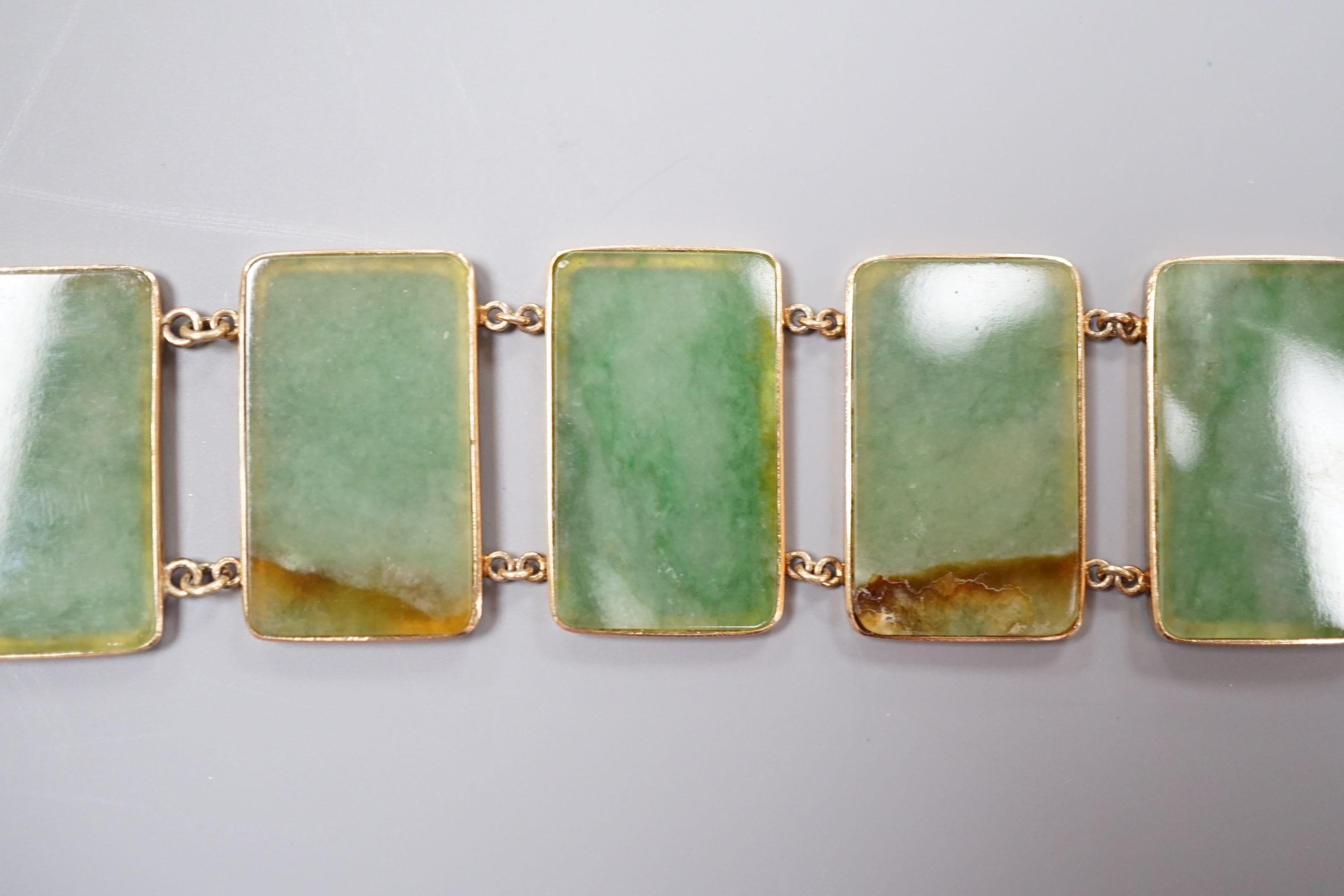 A 585 yellow metal and jade bracelet, set with eight rectangular panels, 18cm, gross weight 26.5 grams.